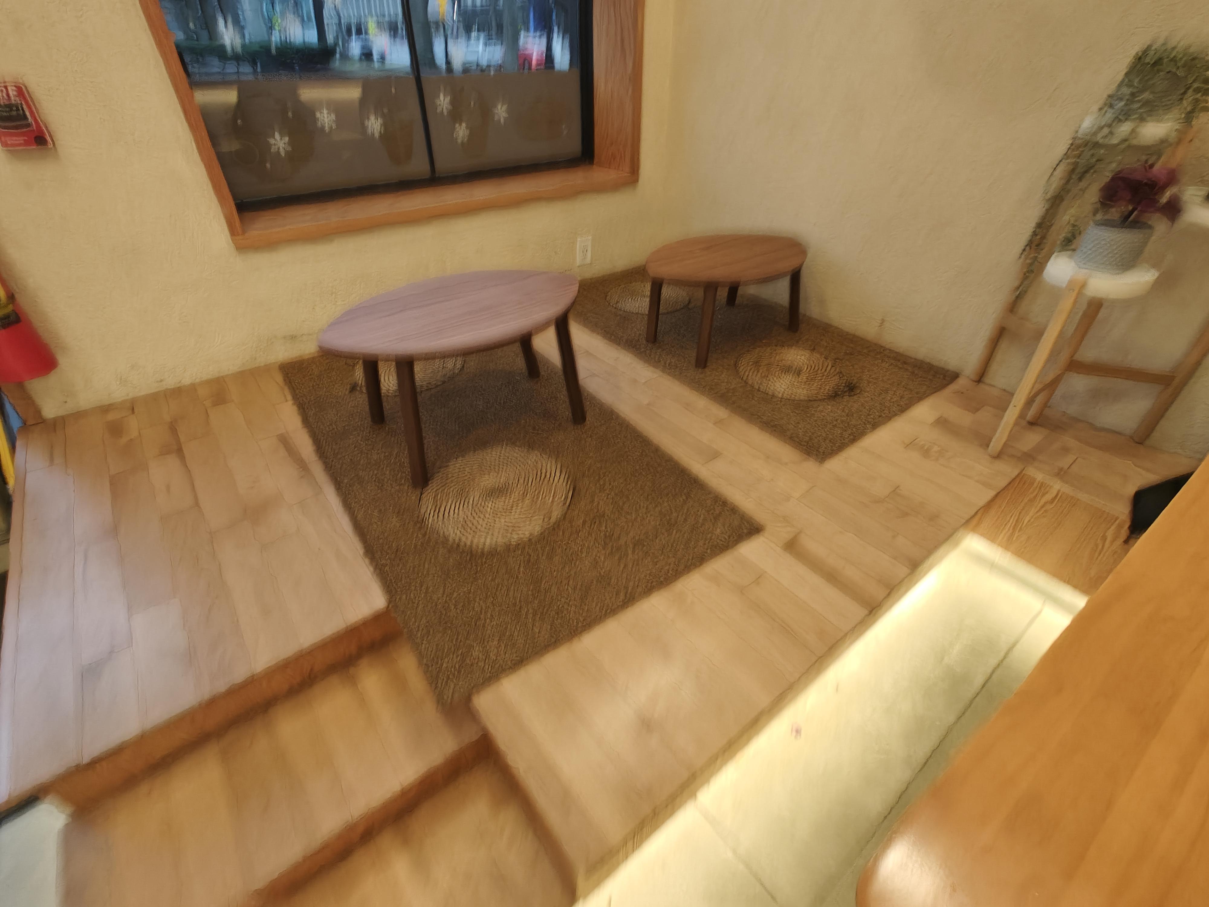 A blurry picture showing they have small tables where you can sit on a raised platform as a more traditional setting.